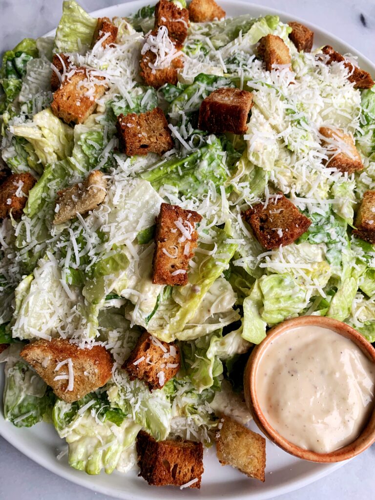 The Best Healthy Classic Caesar Salad with homemade caesar dressing, baked sourdough croutons on top of crunchy romaine with a sprinkle of fresh parmesan cheese.